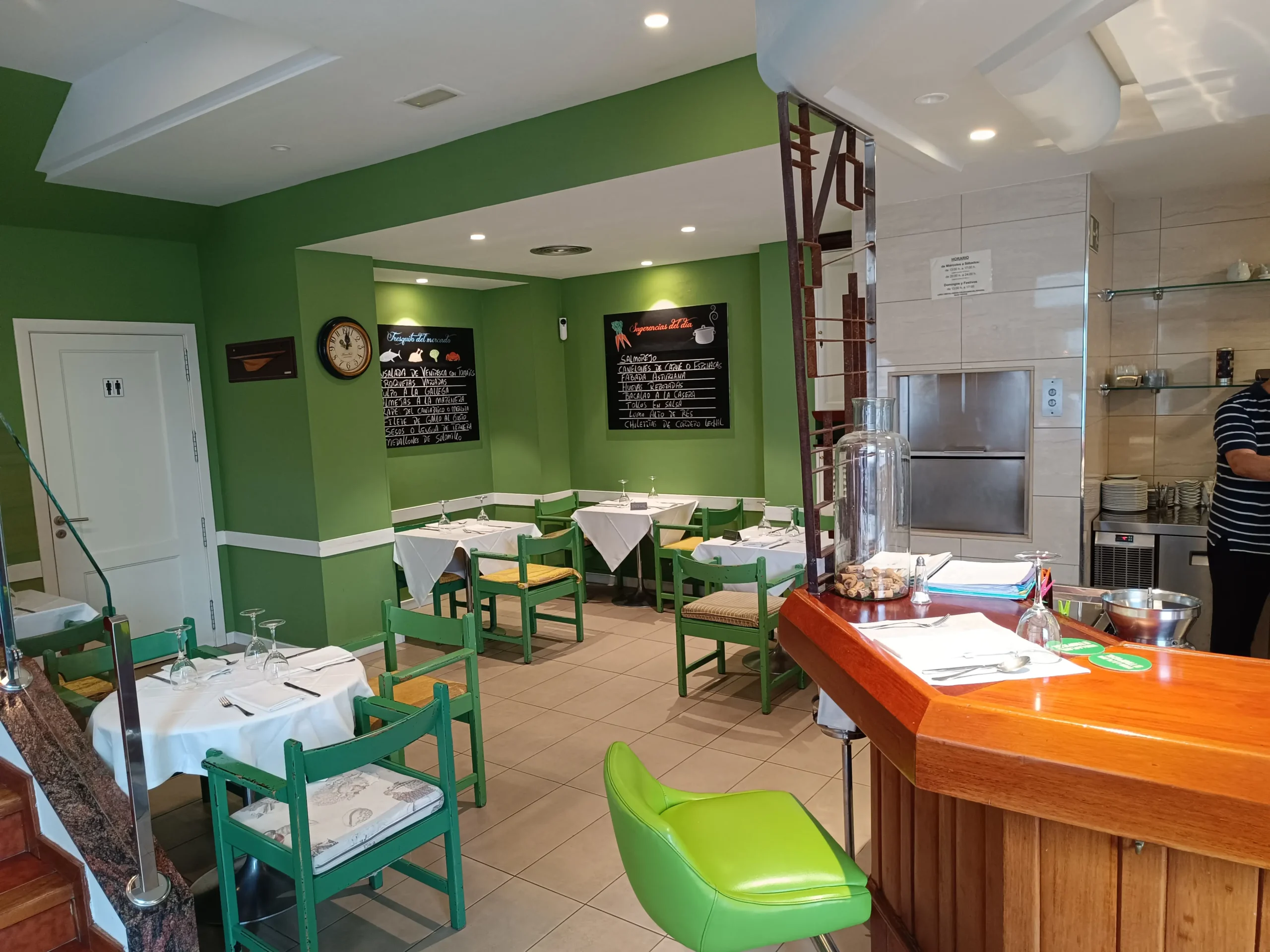 Área del comedor del Restaurante Samoa con mesas y sillas en ambiente decorado en tonos verdes.