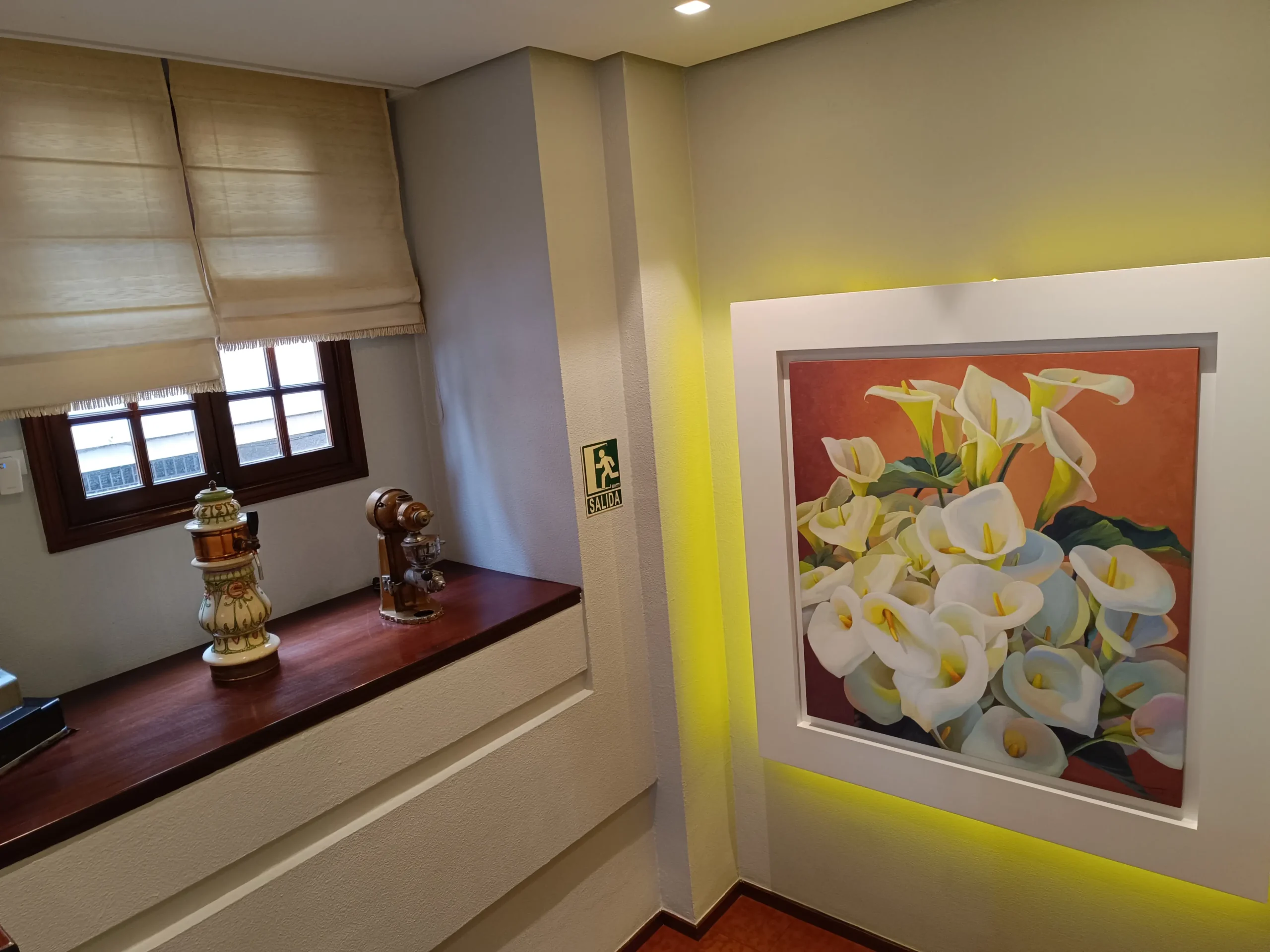 Decoración en la escalera del Restaurante Samoa con un cuadro de calas y elementos decorativos tradicionales.